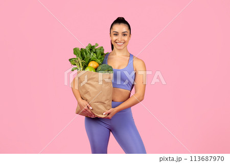 Woman holding bag of fresh groceries 113687970