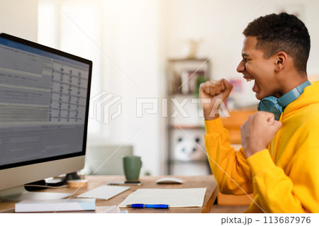 Focused individual coughing while working on computer 113687976