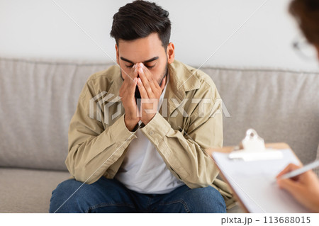 Despondent man in therapy session with counselor Despondent man in therapy session with counselor 113688015