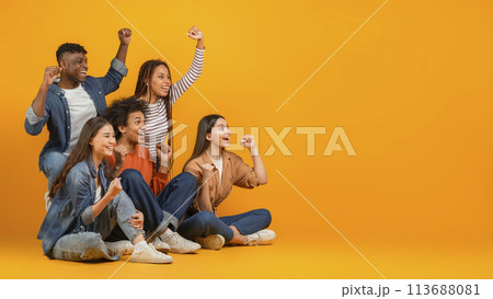 Group of friends cheering and celebrating on orange background 113688081