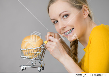 Woman holding shopping cart with bread 113688087
