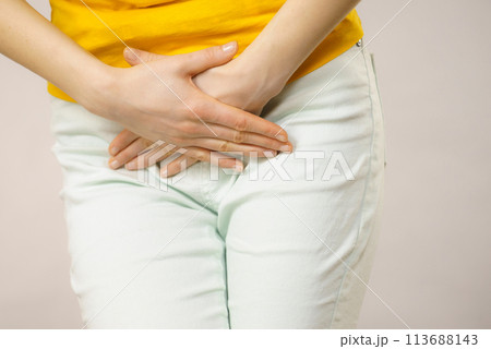 Woman with hands holding her crotch 113688143