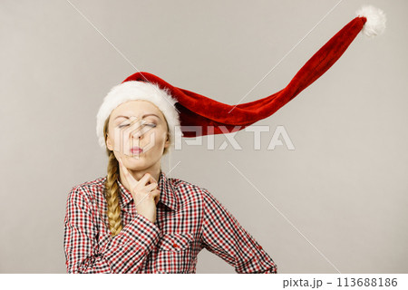 Funny girl wearing blowing santa claus hat Funny girl wearing blowing santa claus hat 113688186