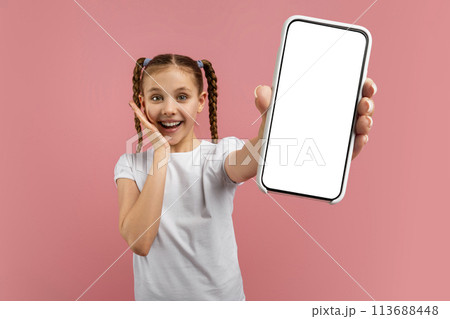 Young girl showing smartphone screen, smiling 113688448