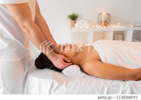 Woman receiving a relaxing head massage at spa 113688645