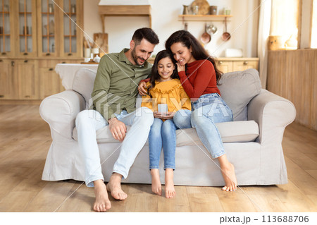 Family viewing phone together on couch at home 113688706