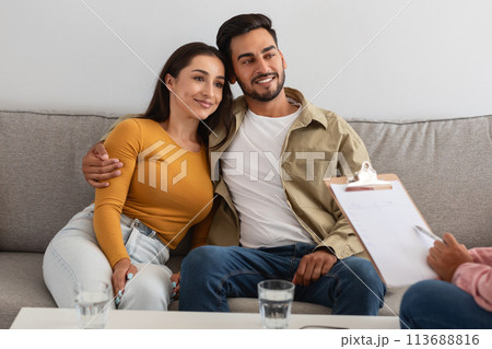 Happy couple embracing on sofa at clinic 113688816