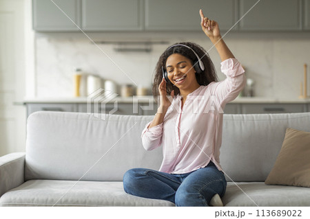 Lady dancing with headphones on at home 113689022