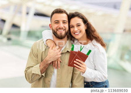 Portrait of couple holding passports and smiling 113689030