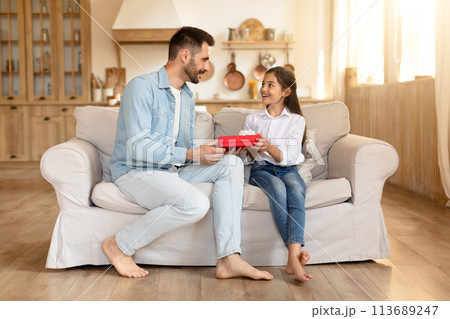 Father and daughter sharing a special gift moment 113689247