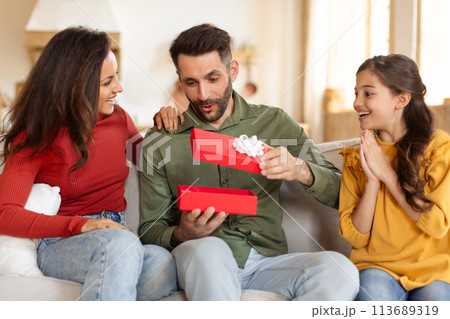 Family opening gift with excitement at home Family opening gift with excitement at home 113689319