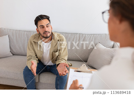 Middle eastern man speaking with therapist on couch Middle eastern man speaking with therapist on couch 113689418