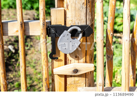 New metal padlock on a bright yellow wooden fence 113689490