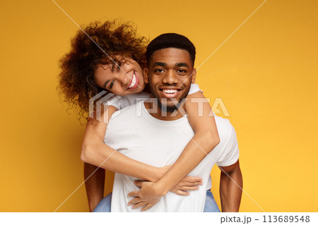 Cute couple in love embracing on orange background Cute couple in love embracing on orange background 113689548