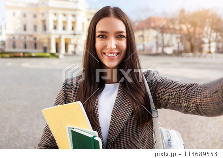 Selfie-taking woman student with a beaming smile 113689553