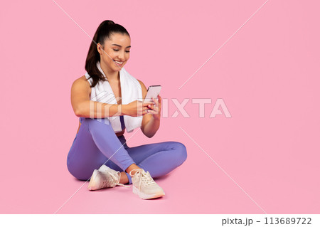 Woman using smartphone after workout session 113689722