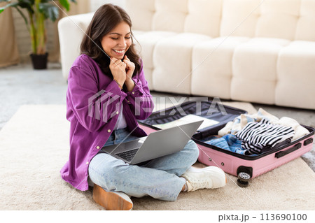 Happy middle eastern woman with laptop and suitcase Happy middle eastern woman with laptop and suitcase 113690100
