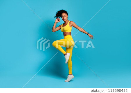 Sporty woman in a dynamic yoga pose on blue 113690435