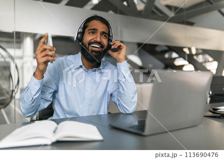 Smiling man with headset working in office Smiling man with headset working in office 113690476