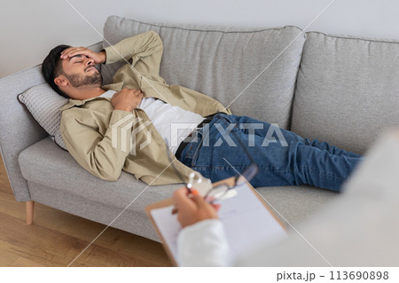 Man lying on couch during a therapy session 113690898