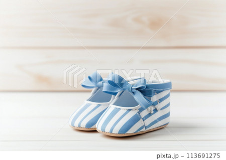 Newborn striped baby shoes on wooden background 113691275