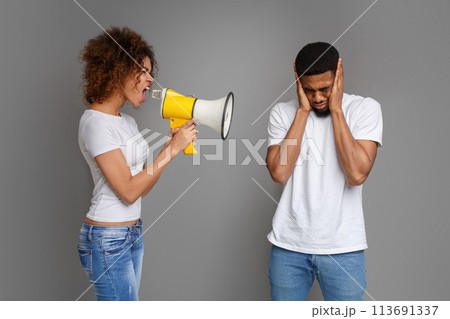 African-american girl shouting through megaphone at her boyfriend African-american girl shouting through megaphone at her boyfriend 113691337