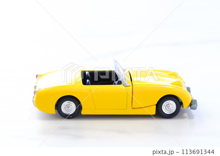 黄色の二人乗りのオープンカーで気ままなドライブ旅行に出るイメージ画像 113691344
