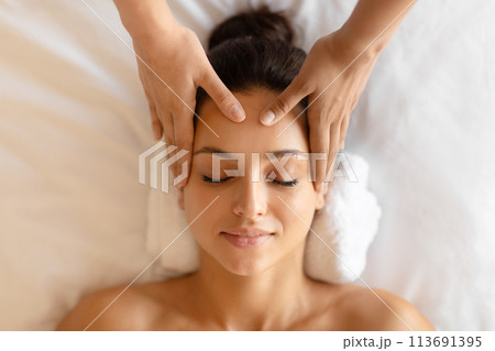 Closeup of young woman receiving relaxing head massage indoor 113691395
