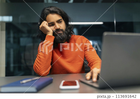 Tired millennial eastern man startuper working late at night 113691642
