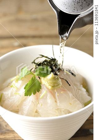 三つ葉、刻み海苔、わさびが乗った鯛茶漬けに出汁を注ぐ 113691841