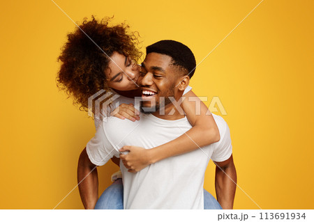 African american millennial couple fooling together, girl kissing her boyfriend 113691934