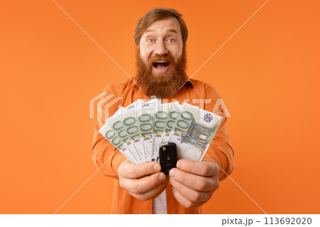 Portrait bearded man showing new car key and euro money 113692020