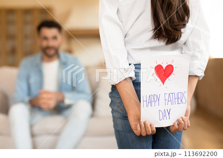 Girl holding a Father's Day card at home 113692200