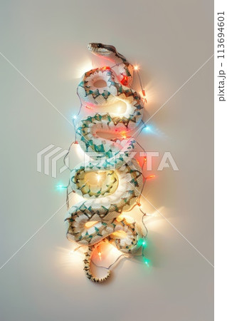 Enchanted Festive Serpent Wrapped in Christmas Lights and Pine Enchanted Festive Serpent Wrapped in Christmas Lights and Pine 113694601