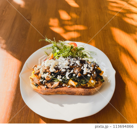 Healthy breakfast with srambled eggs, spinach and on toasted sourdough bread. 113694866