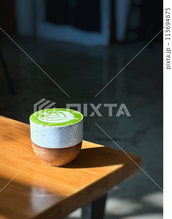 Cup of matcha latte green tea on wooden table. Cup of matcha latte green tea on wooden table. 113694875