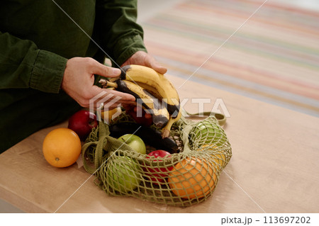 Man holding bunch of rotten bananas 113697202