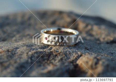 Silver or white gold ring with diamonds and pink sapphires on natural rock background. Precious gems and metals, natural gemstone jewelry 113697791