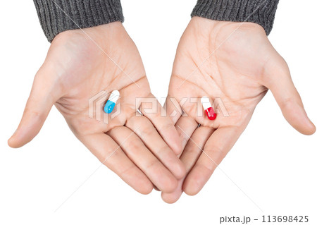 Hands with red and blue pills. Choose a treatment. Alternative concept. 113698425