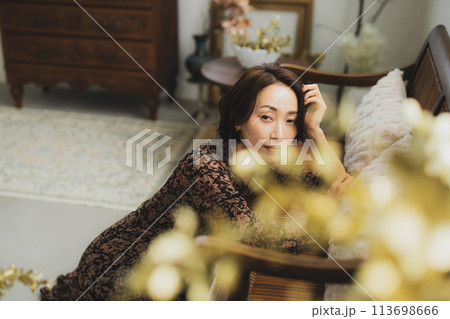 部屋のソファに座っているミドル女性  113698666