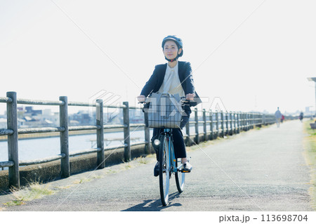 自転車に乗って通勤するミドル女性 113698704