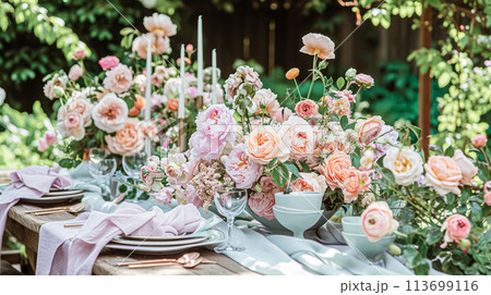 Table setting with rose flowers and candles for an event party or wedding reception in summer garden. 113699116