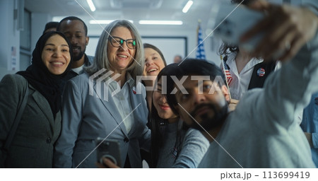 Happy diverse people take pictures with female presidential candidate after voting 113699419