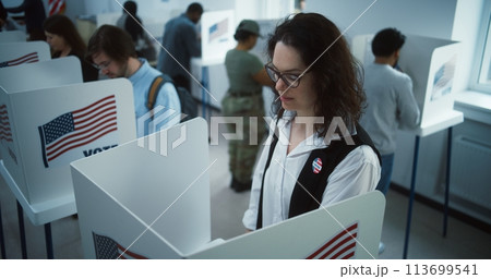 National Election Day in United States. Woman votes in booth National Election Day in United States. Woman votes in booth 113699541