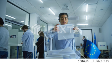 Caucasian male voter puts ballot paper in box during EU elections 113699549