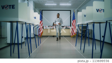 African American male voter takes paper ballot at polling station African American male voter takes paper ballot at polling station 113699556