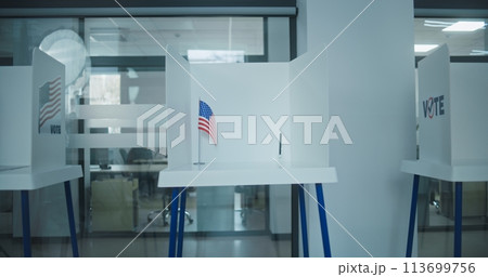 Dolly shot of voting booths with American flag logo in polling station office 113699756