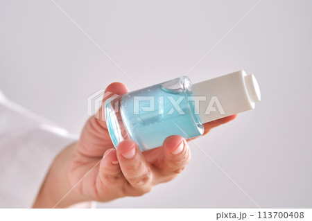 Blue serum with pipette in a womans hands in a robe. 113700408