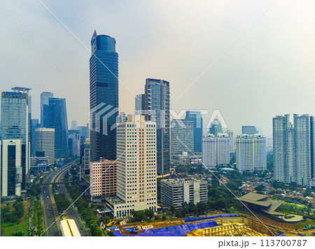 Aerial view of cityscape on Jalan Jenderal Sudirman in Jakarta, Indonesia. Tall skyscrapers line the busy street. 113700787