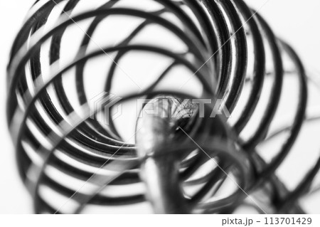 Metal spring coiled, black and white macro shot 113701429